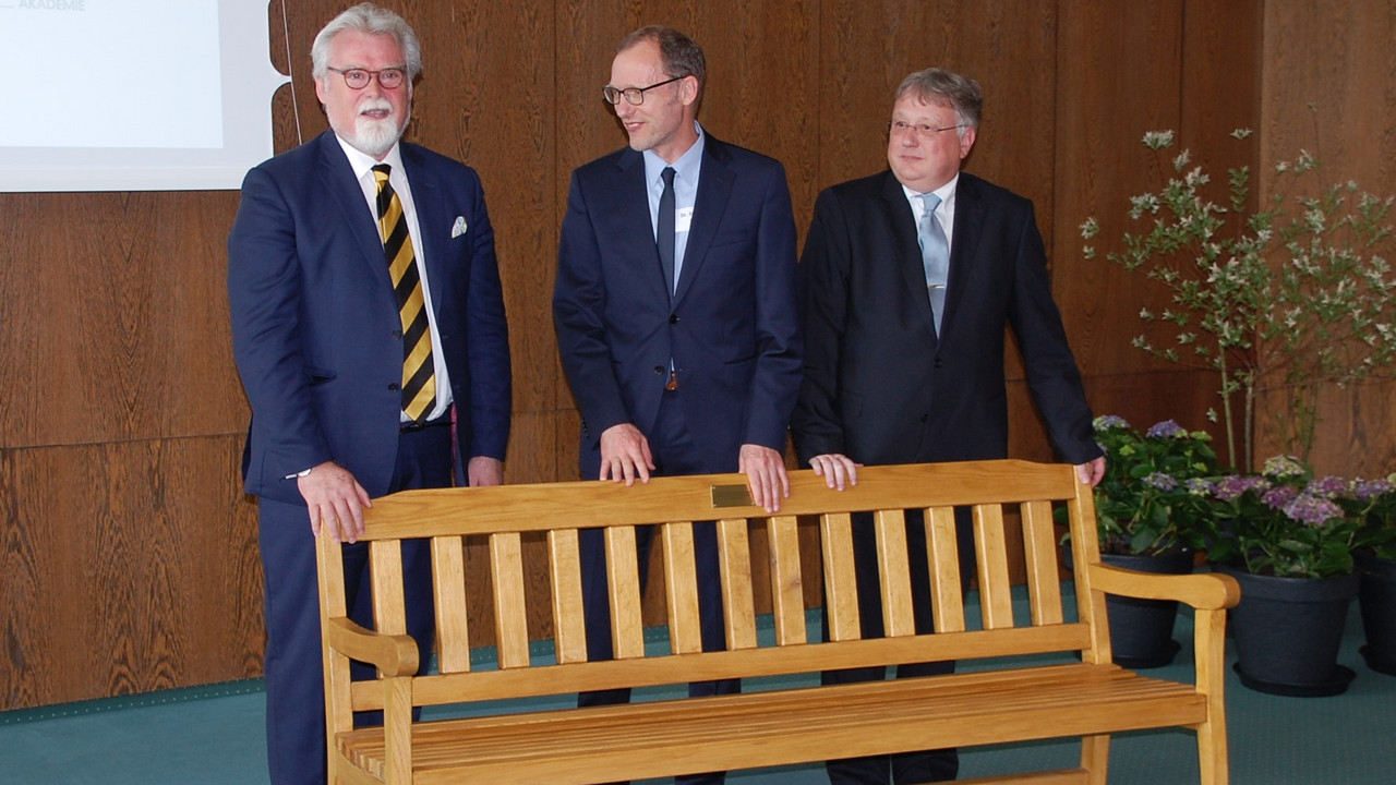 Justizminister Herbert Mertin übergibt das Geschenk des Ministeriums der Justiz anlässlich des 50-jährigen Jubiläums der DRA - eine Sitzbank gefertigt in der JVA Wittlich.