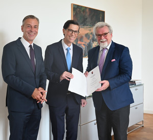 Das Bild zeigt: Prof. Dr. Lars Brocker, Dr. Jörg Schumacher und Justizminister Herbert Mertin