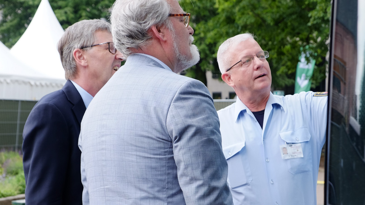 Justizminister Herbert Mertin, Staatssekretär Dr. Matthias Frey und der Cheffahrer des Gefangenenbusses beim Ansehen der Routenpläne