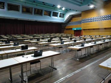 Prüfungssaal mit Tischen, Stühlen und Notebooks