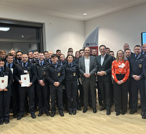 Das Bild zeigt: Die Absolventinnen und Absolventen der Justizvollzugsschule Rheinland-Pfalz mit Justizminister Philipp Fernis, Staatssekretär Dr. Jens Diener und die Leiterin der Justizvollzugsschule Birgit Kunz-de Boer.