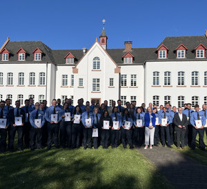 Das Bild zeigt: Die Absolventinnen und Absolventen der Justizvollzugsschule Rheinland-Pfalz mit Justizminister Philipp Fernis, Staatssekretär Dr. Jens Diener und die Leiterin der Justizvollzugsschule Birgit Kunz-de Boer.
