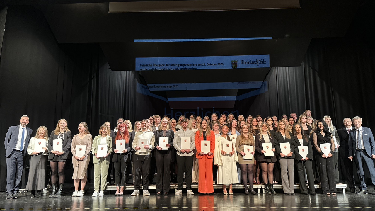 das Bild zeigt: Gruppenfoto der Absolventinnen und Absolventen mit Staatssekretär Dr. Matthias Frey, dem Präsidenten des Oberlandesgerichts Koblenz Thomas Henrichs und dem Vizepräsidenten des Pfälzischen Oberlandesgerichts Zweibrücken Ernst Friedrich Wilhelm