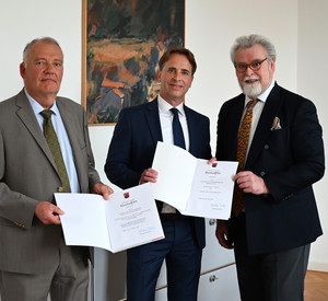 Martin Wildschütz, Matthias Hambach und Justizminister Herbert Mertin mit Urkunden in den Händen